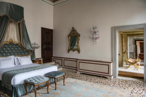 a bedroom with a bed and two chairs in it at Hotel Nani Mocenigo Palace in Venice