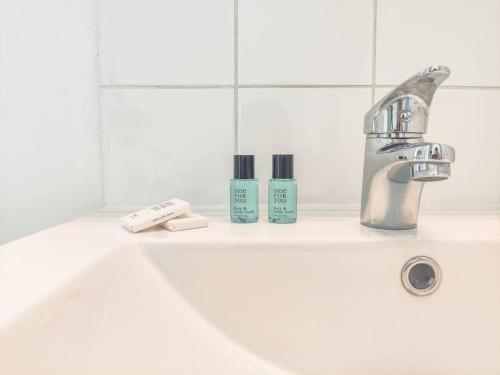 - un lavabo avec un robinet et 2 bouteilles de savon dans l'établissement F2 hypercentre - Proche gare- WIFI gratuite, au Havre