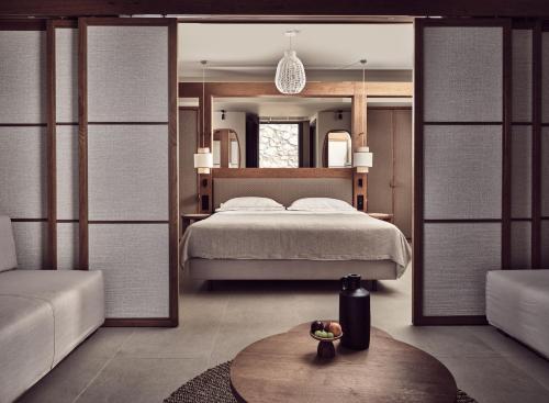 a bedroom with a bed and a large mirror at The Royal Senses Resort & Spa Crete, Curio Collection by Hilton in Panormos Rethymno