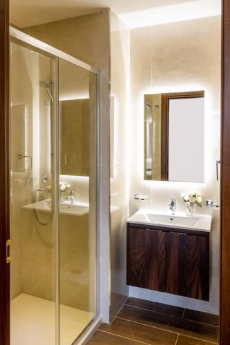 a bathroom with a glass shower and a sink at The Siggiewi Suites in Siġġiewi