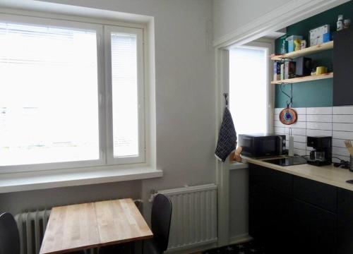 a kitchen with a table and a sink and a window at Studio in the center area with free street parking in Vaasa