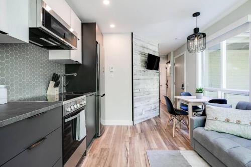 a kitchen and living room with a couch and a table at Le Petit Condo B - Ski In/ Ski Out Mont-Tremblant in Mont-Tremblant
