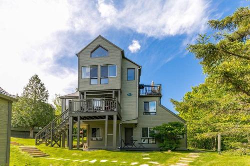 a large house with a balcony on top of it at Le Petit Condo B - Ski In/ Ski Out Mont-Tremblant in Mont-Tremblant