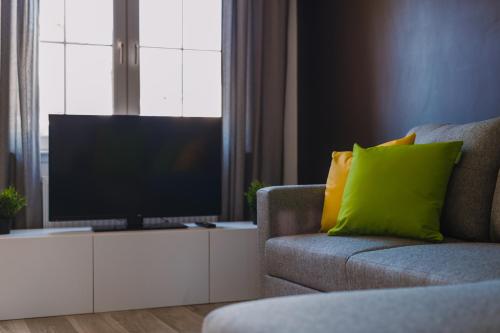 格拉斯哥的住宿－Emirates ApartHOUSE，一间带电视和沙发的客厅