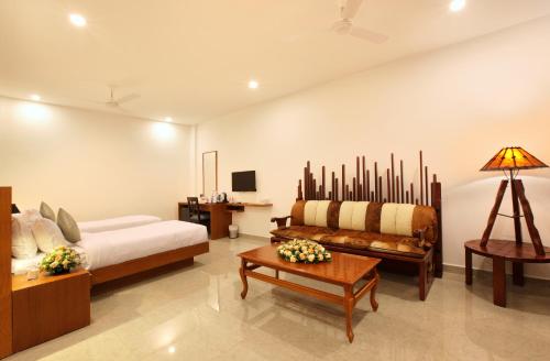 a bedroom with a bed and a couch and a table at HOTEL PRINCE in Kāladi
