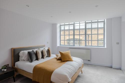 a bedroom with a bed with a large window at Law & Order - Farringdon - by Frankie Says in London