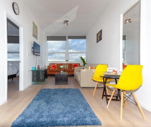 uma sala de estar com cadeiras amarelas e um tapete azul em One Bedroom Apartment Smethwick Flat 308 em Birmingham