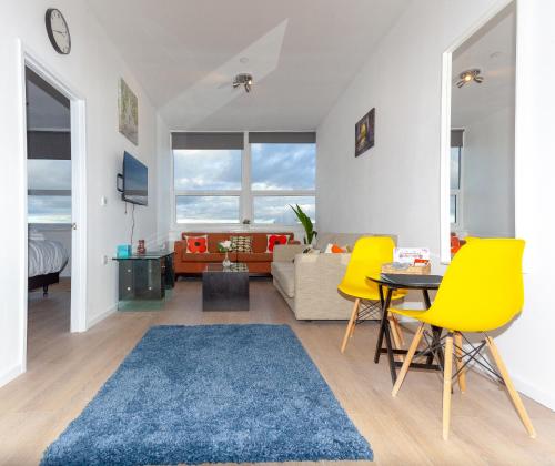 a living room with yellow chairs and a blue rug at One Bedroom Apartment Smethwick Flat 308 in Birmingham