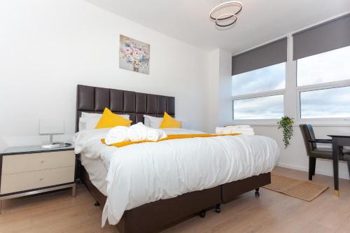 um quarto com uma cama grande e almofadas amarelas em One Bedroom Apartment Smethwick Flat 308 em Birmingham