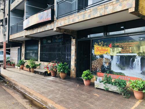 a store with potted plants in front of a building at La Familia Hotel in Puerto Iguazú