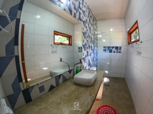 a bathroom with a sink and a toilet and a mirror at Chalés Cumuruxatiba in Cumuruxatiba