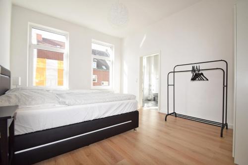 biała sypialnia z łóżkiem i białą ścianą w obiekcie Air Apartments 3 w Bremie