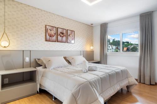 Ένα ή περισσότερα κρεβάτια σε δωμάτιο στο Apto 2 Suítes 30m Rua Coberta by Achei Gramado