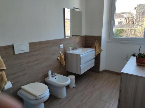 a bathroom with a white toilet and a sink at Villa ARA blu in Canegrate
