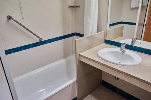a bathroom with a sink and a bath tub at Hotel Varandas do Atlântico by RIDAN Hotels in Praia da Vitória