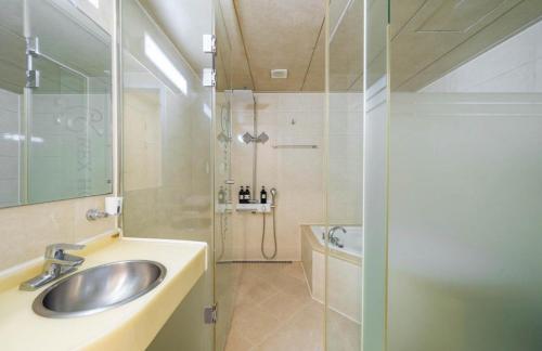 y baño con lavabo y ducha. en Rex Hotel en Cheonan