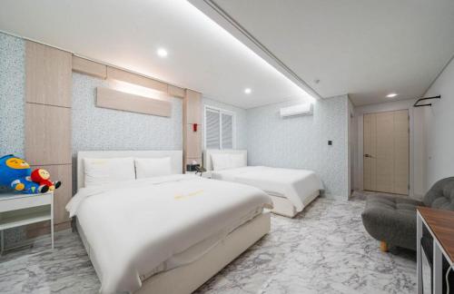 Habitación de hotel con 2 camas y sofá en Rex Hotel en Cheonan