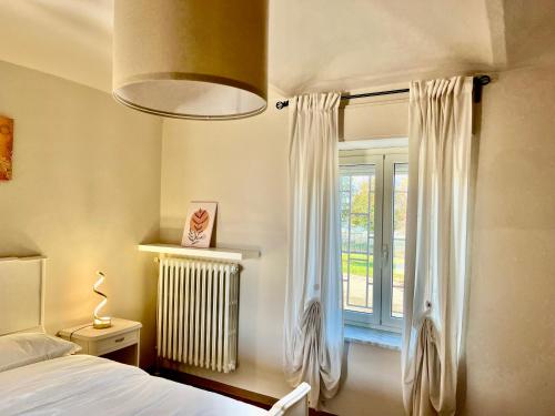 1 dormitorio con cama y ventana en Cascina Montè, en Guarene