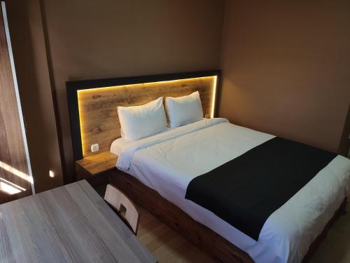a bedroom with a large bed with a wooden headboard at ONKA OTEL in Zonguldak