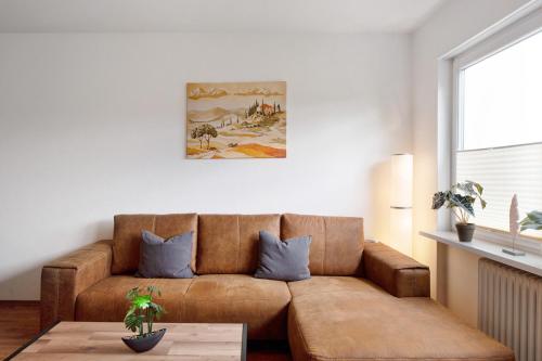 a living room with a brown couch and a table at Agricola in Bad Säckingen