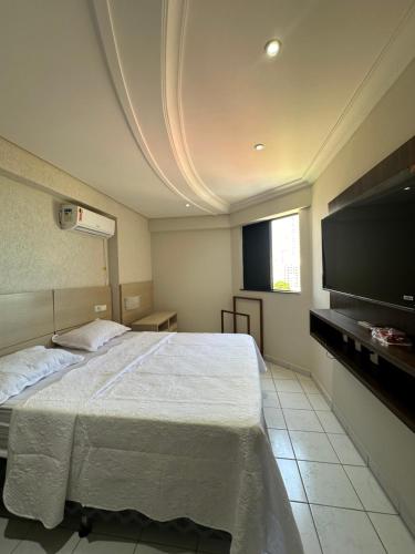 een slaapkamer met een groot bed en een flatscreen-tv bij 601 Maximum Home in Natal