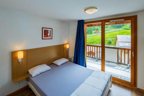 a bedroom with a large bed and a balcony at SUNWEB Résidence Les Balcons & Chalets de Bois Méan in Les Orres