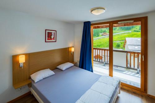a bedroom with a large bed and a balcony at Noemys Balcons de Bois Méan in Les Orres