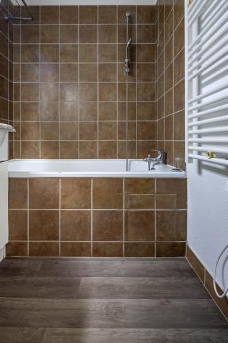 une salle de bain avec une baignoire et un lavabo dans l'établissement SUNWEB Les Balcons de Bois Méan, aux Orres