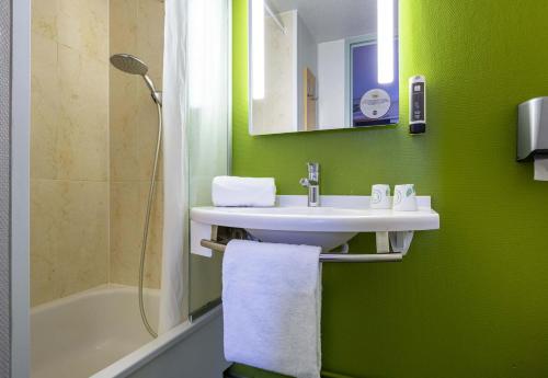 baño con lavabo y pared verde en B&B HOTEL CHARTRES Le Forum, en Chartres