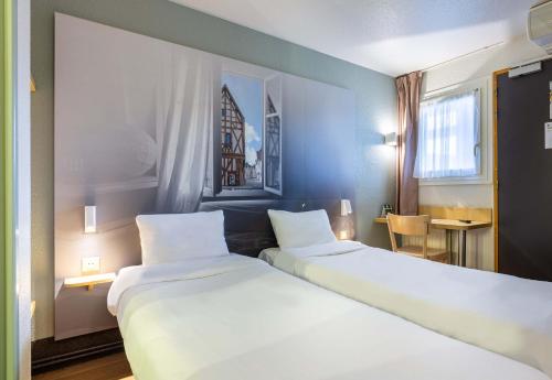 2 Betten in einem Hotelzimmer mit in der Unterkunft B&B HOTEL CHARTRES Le Forum in Chartres