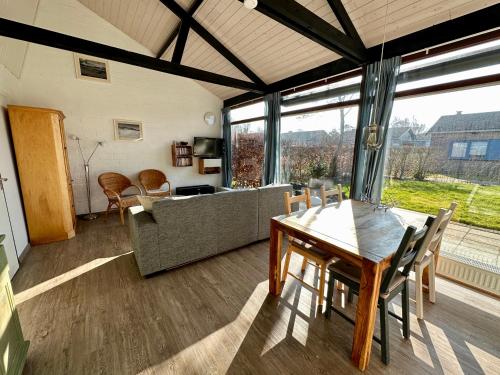 a living room with a table and a couch at Boerenslag 45 in Sint Maartensvlotbrug