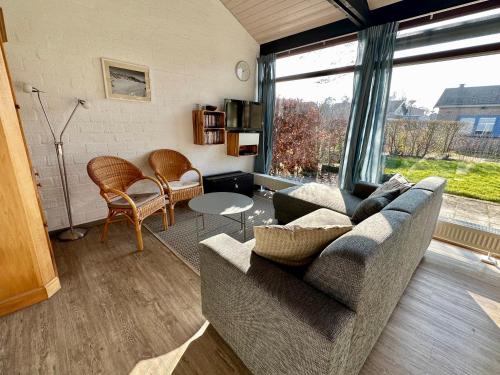 a living room with a couch and a large window at Boerenslag 45 in Sint Maartensvlotbrug