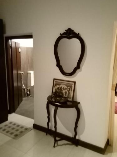 a mirror on a wall next to a table with a picture at The Bliss Hostel Kandy in Kandy