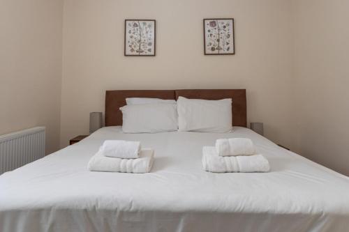 a large white bed with two towels on it at Bright & Contemporary 1bedroom Annexe - Herne Hill! in London