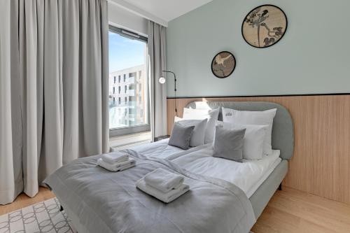 a bedroom with a large bed with two towels on it at Brabank Riverside - Sauna, Business & Gym by Downtown Apartments in Gdańsk