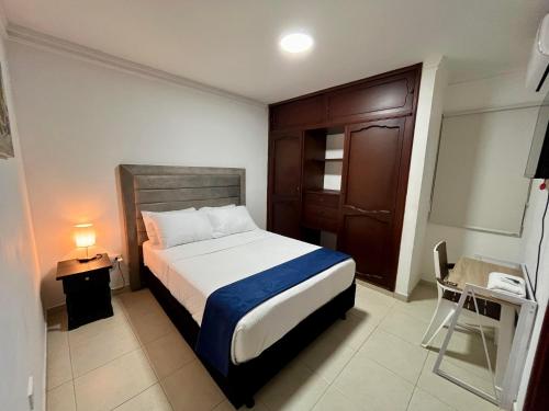 a bedroom with a bed and a table and a lamp at Hotel Boutique Casa Pere in Cartagena de Indias