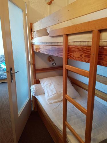 Ce lit superposé se trouve dans une petite chambre dotée d'une porte. dans l'établissement Studio 4 couchages Risoul cœur de la station, à Risoul