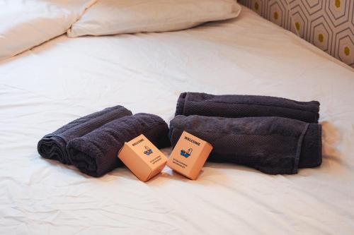 un par de toallas en una cama con dos cajas en 50 m2 Apartment Next To Montmartre en París