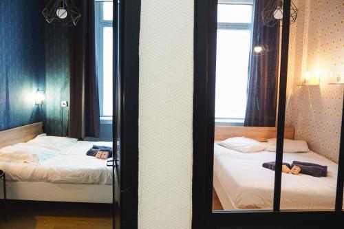 two beds in a room with two mirrors at 50 m2 Apartment Next To Montmartre in Paris