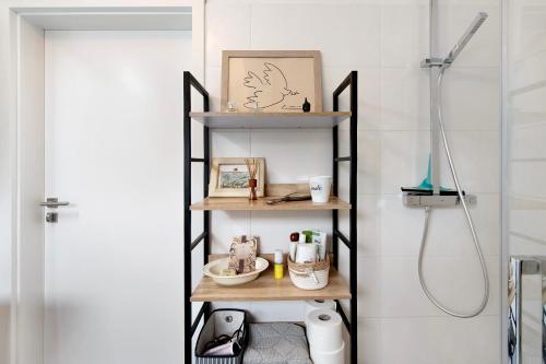 a shelf in a bathroom with a shower at Apartment Dreiländer Blick 