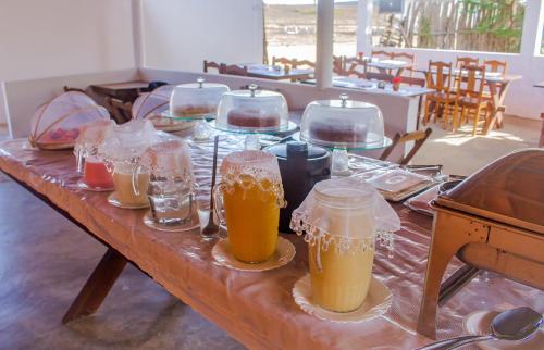 a wooden table with two glasses of beer on it at Pousada Jeri Flats in Jericoacoara