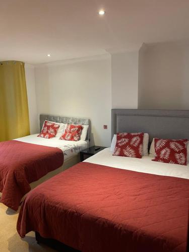 Zimmer mit 2 Betten mit roter und weißer Bettwäsche in der Unterkunft Shared house on Southmead in Bristol