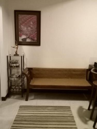 a wooden bench sitting against a wall in a room at The Bliss Hostel Kandy in Kandy