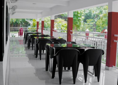 a row of tables and chairs in a restaurant at Rockdale Resort in Nilambūr