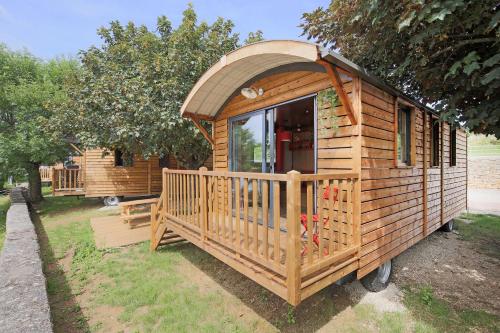 a wooden cabin with a window in a yard at Huttopia Fontvieille in Fontvieille