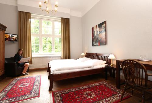 a woman sitting in a window in a bedroom at Hotel Amsterdam in Hamburg