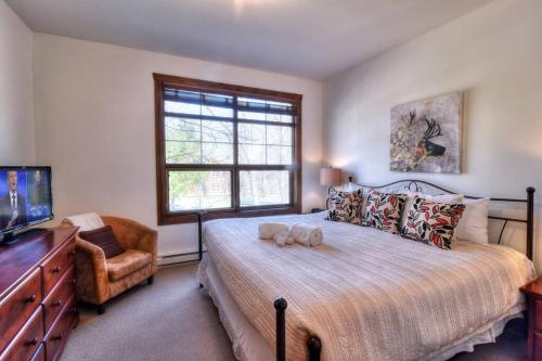 une chambre avec un lit avec un animal en peluche dessus dans l'établissement Tremblant-Les-Eaux C2, à Mont-Tremblant