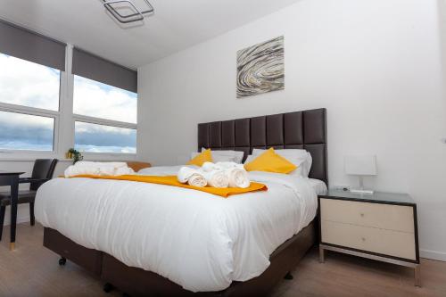 a bedroom with a large white bed with yellow pillows at One Bedroom Serviced apartments Flat 311 in Birmingham