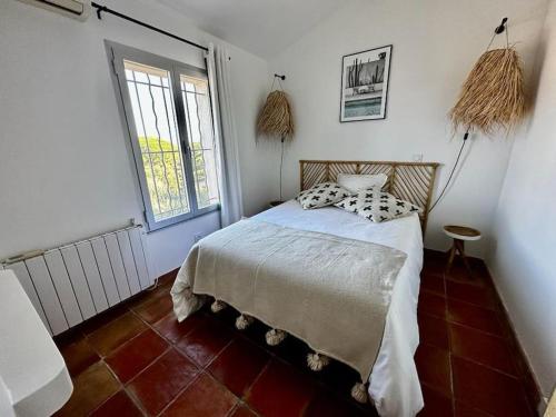 une chambre avec un lit et une grande fenêtre dans l'établissement Le Mas Miliane vous accueille, à Sainte-Maxime