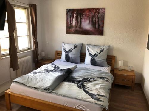 ein Bett in einem Schlafzimmer mit einem Bild an der Wand in der Unterkunft Gästezimmer zur Brücke in Zwiesel